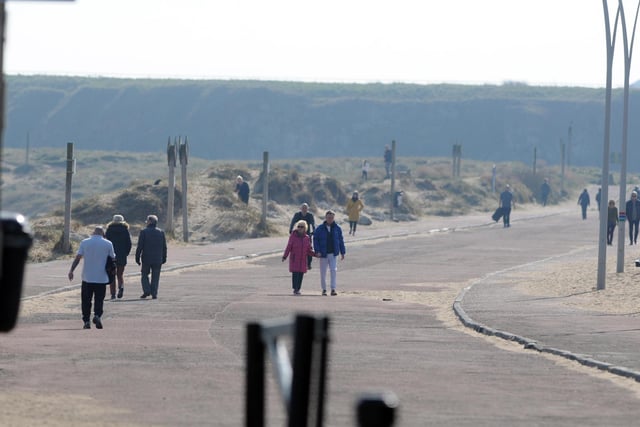 Walkers make sure they are social distancing at Sandhaven beach.