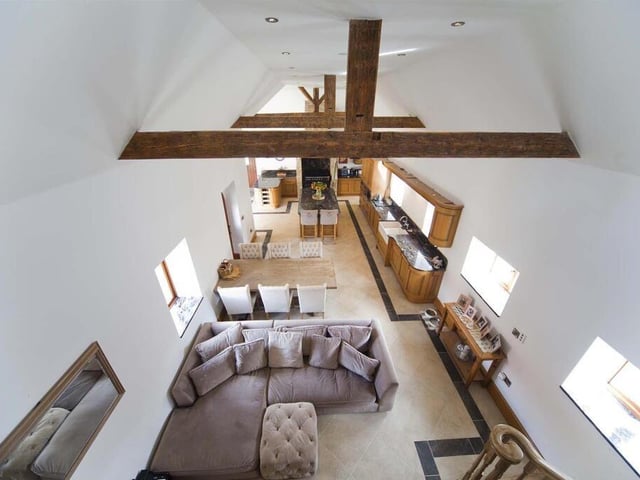 This open-plan kitchen, diner and snug area boasts charm and originality, with exposed beams and vaulted ceiling.