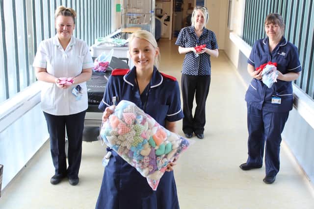 Cath Rucco, second right, pictured earlier this month with fellow staff as they thanked the public for their donations of knitted love-hearts for the relatives of patients.
