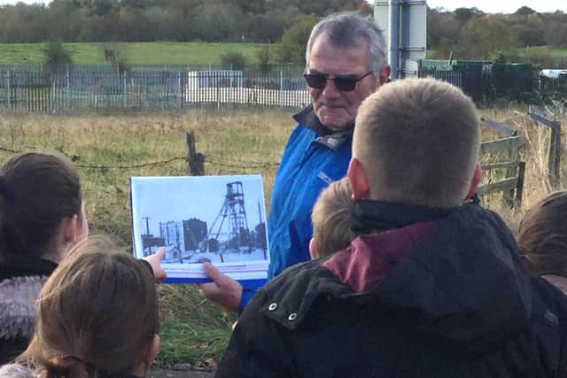Blackhall Local History Group's Stan Gray shows children where part of a mine used to be.