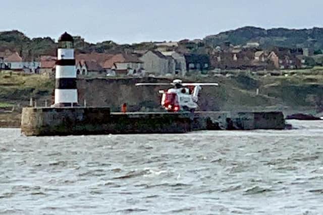 Pictured is a coastguard helicopter landing on the pier to collect the paramedic who attended the incident.