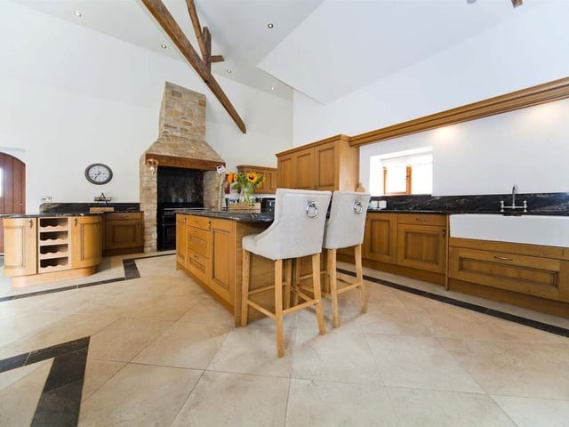 The kitchen is fitted with solid wood units and surfaces as well as integrated ceiling speakers and underfloor heating.
