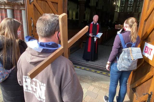 The walkers are greeted at St Joseph's Church by Canon Michael Griffiths for a Good Friday service.