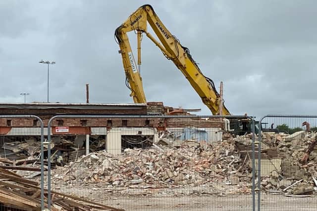 A digger demolishing the old English Martyrs School site.