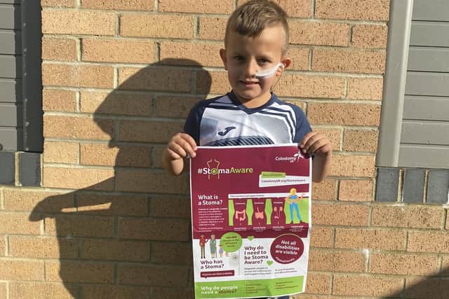 Jack Dale, 7, holding a Stoma Aware poster.