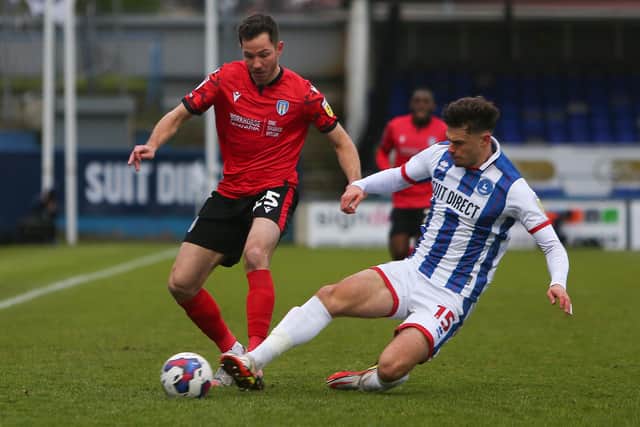 Colchester United's Tom Hopper is tackled by Hartlepool United's Edon Pruti. (Credit: Michael Driver | MI News)