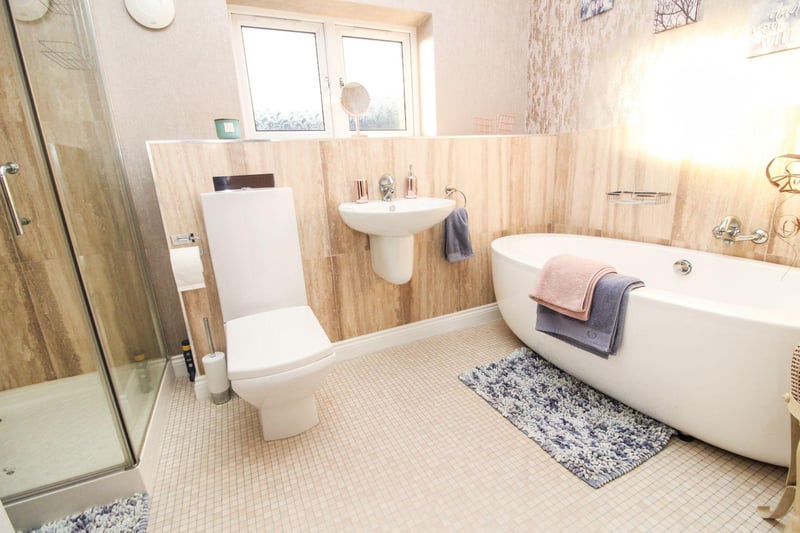 The family bathroom comprises a large bath, shower cubicle, low level toilet and hand wash basin, tiled walls, a radiator and a double glazed frosted window.