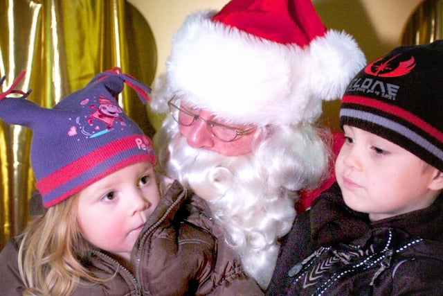 Two rosy-cheeked children tell Santa what they would like for Christmas in the Middleton Grange grotto from 2008.