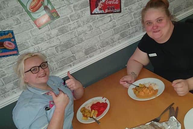 Two staff members at Queens Meadow care home in Hartlepool tuck into food delivered free by the Golden Gate Indian restaurant.