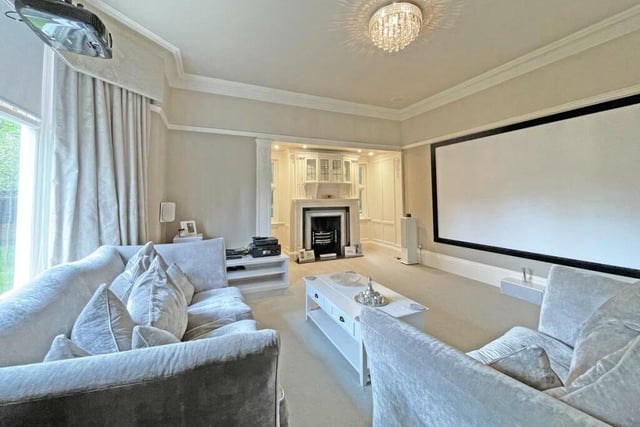 The drawing room has a stunning fireplace and projector screen, perfect for family movie nights.