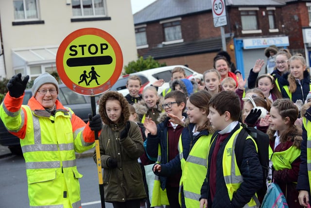 Lollipop man Geoff Chandler on his last day before his retirement with St Cuthbert's RC Primary School children in 208.