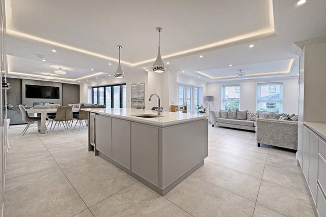 This open plan kitchen space has modern grey fittings and a centred breakfast bar.