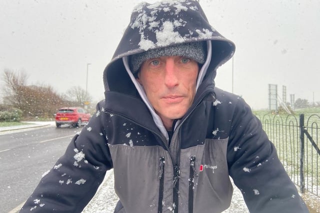 Cyclist Lee Simpson gets caught in a heavy snow shower on the Headland earlier this week.