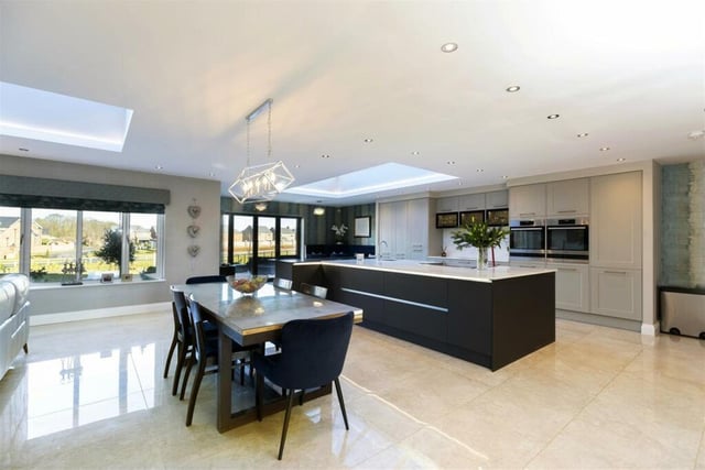 This home has a large, open-plan kitchen, diner and family area featuring a breakfast bar, media wall and inset fireplace.