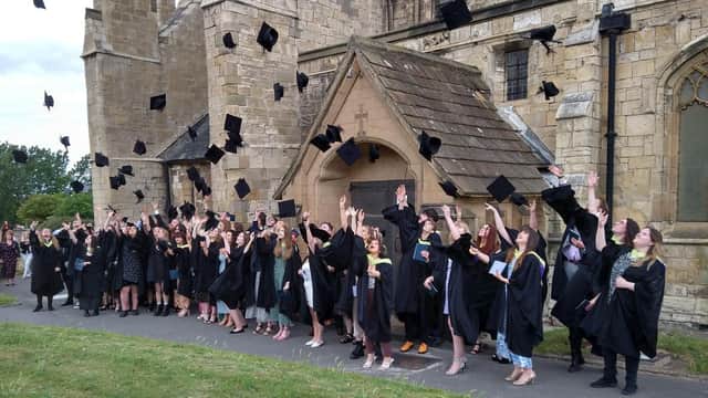 Graduates from The Northern School of Art celebrate outside St Hilda's Church.