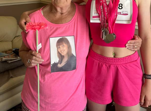 14-year-old Lottie Taylor-Watson stands next to 85-year-old Margaret Wilson after completing her tenth Race for Life.