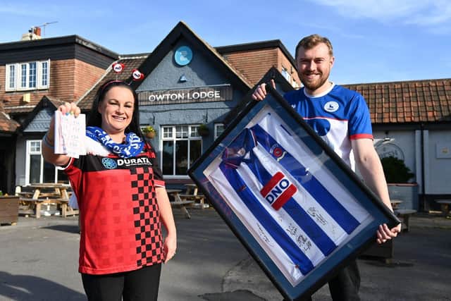 Sarah Lowther, general manager, and Matt Grocott hold the framed Hartlepool United shirt that will be raffled off to raise funds during the charity fun day.