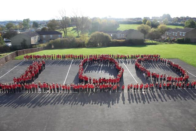 The pupils line up to form the number 100