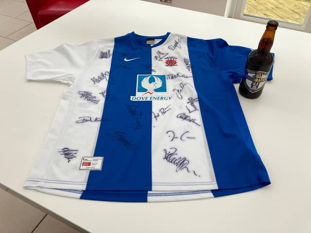 The signed shirt and Camerons bottle of ale that are up for auction.