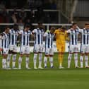 Hartlepool United's players stand in silence in memory of former player Lenny Johnrose before the start of Tuesday's Sky Bet League Two match with Tranmere Rovers. (Credit: Mark Fletcher | MI News)