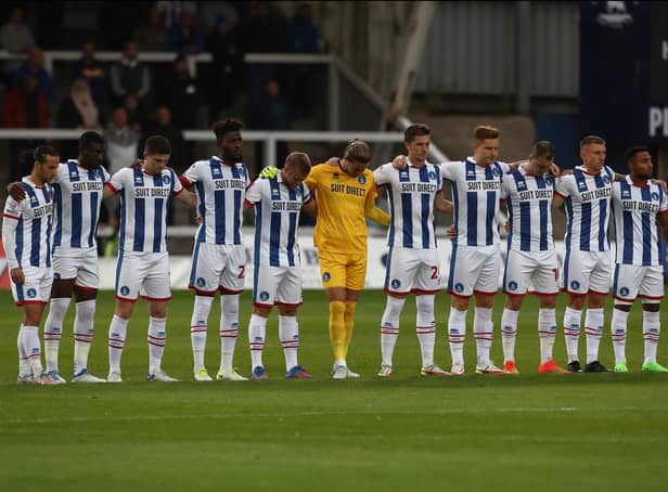 Hartlepool United's players stand in silence in memory of former player Lenny Johnrose before the start of Tuesday's Sky Bet League Two match with Tranmere Rovers. (Credit: Mark Fletcher | MI News)