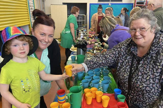 Teaching assistant Jayne Cowan with pupil Jared Raine as he serves a drink to his nana Christine Brown who also  attended the coffee afternoon.