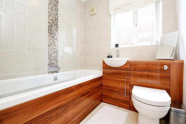 The family bathroom features a panelled bath with shower over.