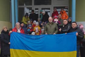 David Pond (right of centre) and Andy behind him to the right holding up a child, during a visit to children in the village of Muzykivka.