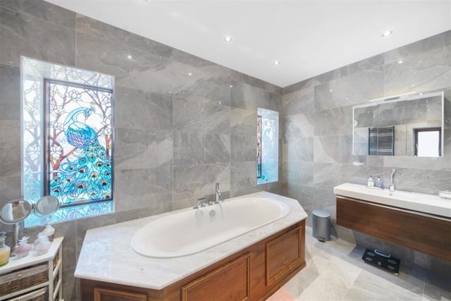 The family bathroom boasts stunning stained glass windows and a sauna.