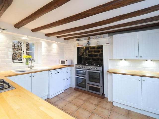 The kitchen at the Riddings cottage is very distinguished, particularly with its feature range cooker. Note also its inset gas hob and extractor hood over, dishwasher, tiled flooring and spotlights.