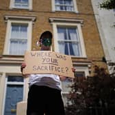A protester holds a sign up outside the home of Prime Minister Boris Johnson's senior aide Dominic Cummings in north London. Picture: PA.