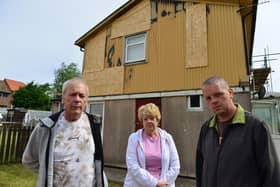 William and Fiona with their son William Holland (right) outside of their damaged home.