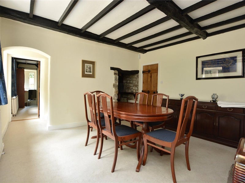 The formal dining room has a characterful feel with the dark wood ceiling beams and charming stone alcove, and provides plenty of space for entertaining.