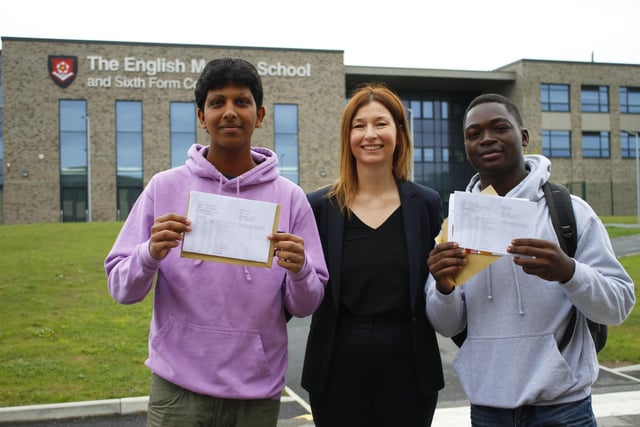 Two pupils celebrate their GCSE results with English Martyrs headteacher Sarah Crawshaw.