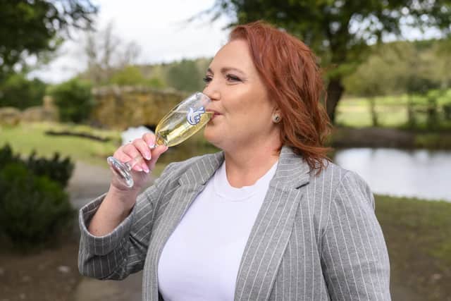 Joanne Jobson enjoys a sip of champagne after her lottery win. Photo by Anthony Devlin.