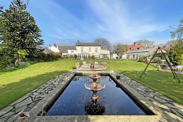 The rear garden is complete with a pond with an ornate fountain.