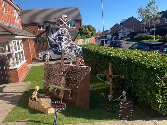 Skeletons aboard a pirate ship outside this house. Enter if you dare!