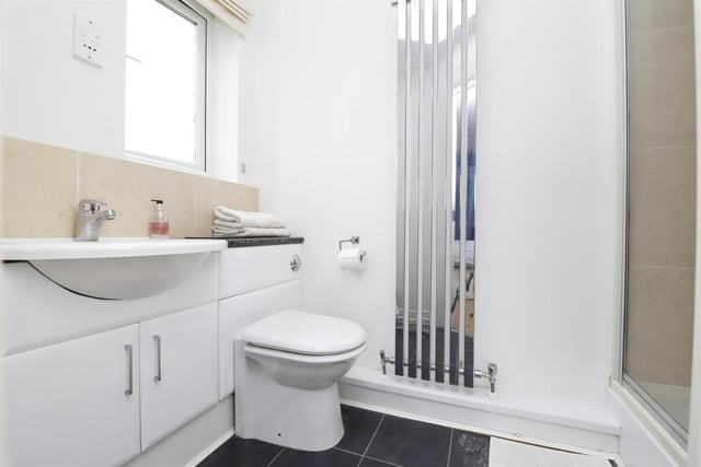 The en-suite includes a shower cubicle and built-in storage.