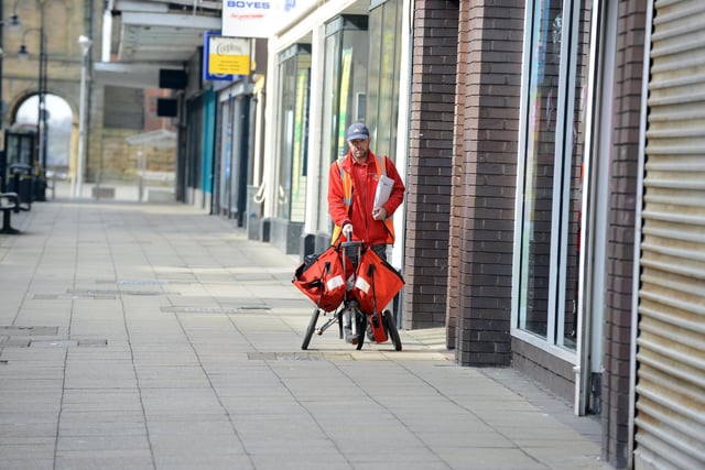 A postman delivers the mail on an empty King Street.