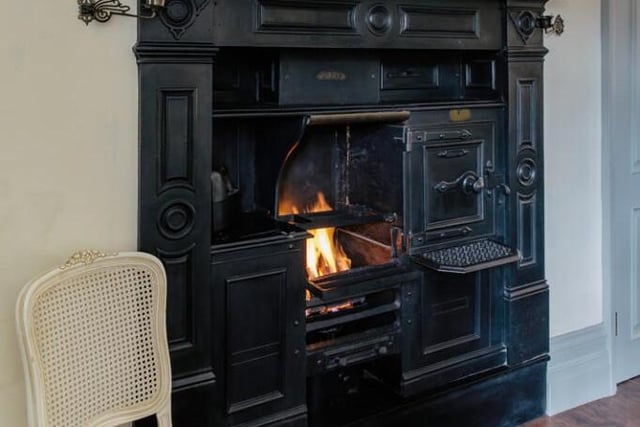 The kitchen features a large cast iron with a working fire.