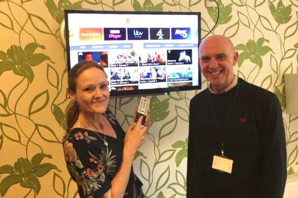 Sandra Britten and Vince Gibson with one of the smart TVs at Alice House Hospice.