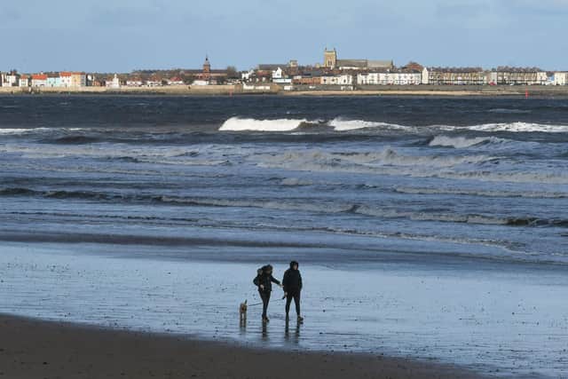 Walkers out on Seaton Carew beach.