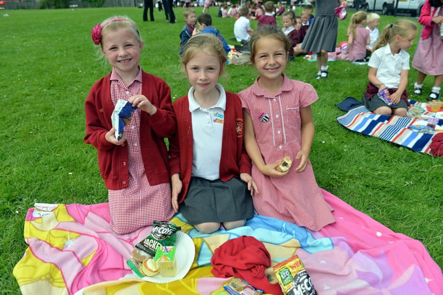 School pupils Sophie Wayper, Bonnie Costello and Emily Hewitt enjoy some snacks at the school's 100th anniversary picnic in 2014.