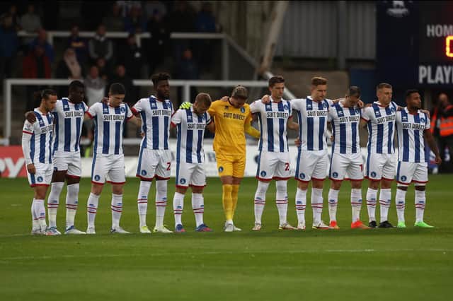 Hartlepool United's players stand in silence in memory of former player Lenny Johnrose who passed away this week during the Sky Bet League Two match between Hartlepool United and Tranmere Rovers. (Credit: Mark Fletcher | MI News)