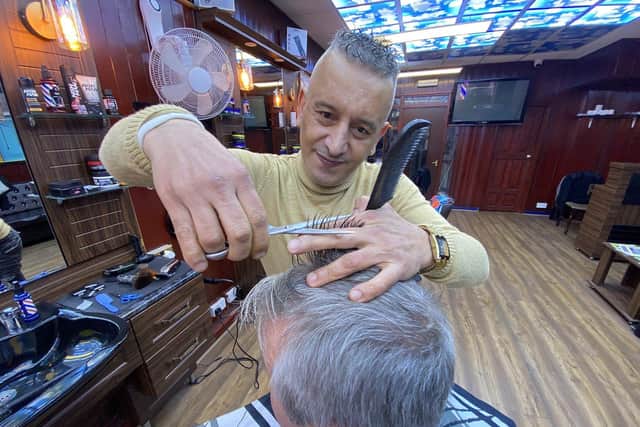 Barber Hassan Hawleri busy at work in King Kutz.