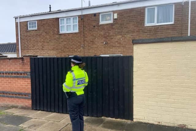 A police officer at the rear of properties in Ivy Gove, Hartlepool, on Friday morning following the launch of an investigation into a woman's death.