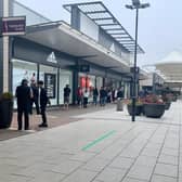 Shoppers can be seen queuing to get into shops at the outlet centre.