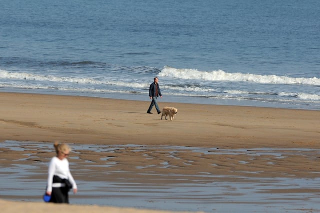 Dog walkers keep their distance on Sandhaven beach.