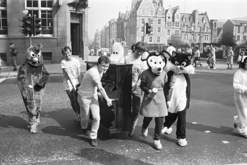 Students in fancy dress push a piano up the Royal Mile in aid of Edinburgh Universities Caharities Appeal in April 1987