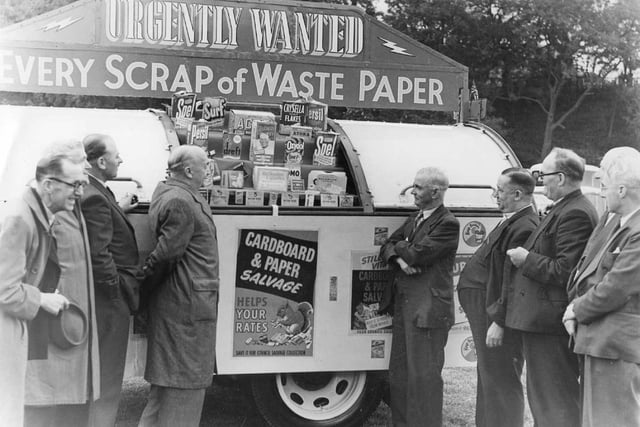 Local men stand around a stall seemingly appealing to the public to save every last scrap of paper they have. Does anyone know the reason behind this?